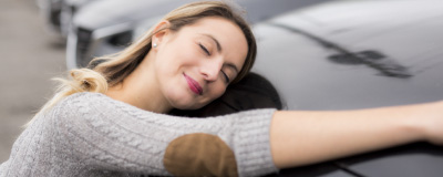 Foto de mujer abrazando un vehículo